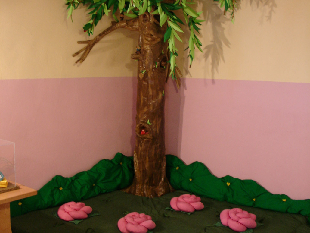 Interno della sezione ragazzi della Biblioteca Comunale di Lanciano, con un finto albero e un tappeto verde dove i bambini si possono sedere per leggere